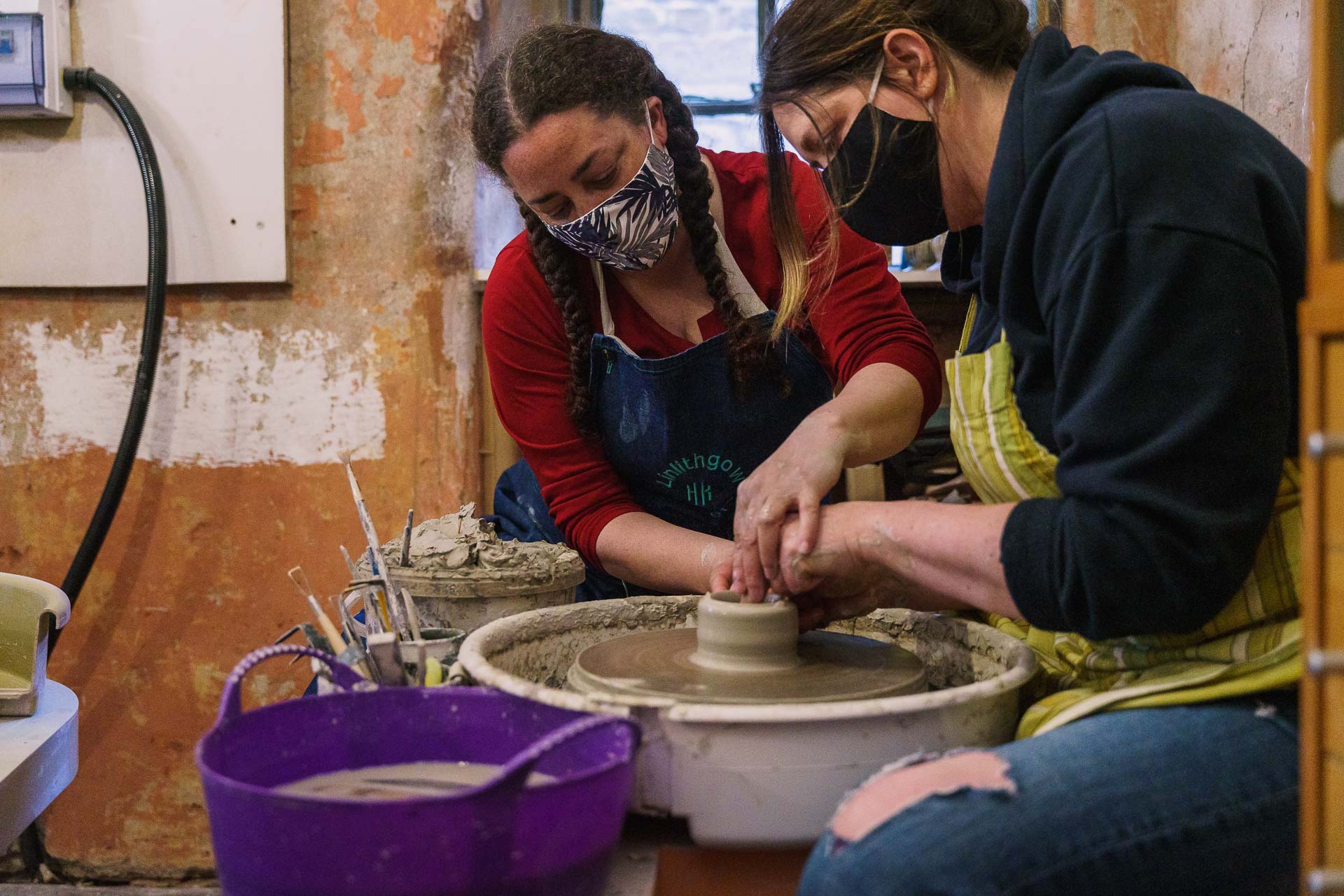 a group of people working on a pottery wheel at Linlithgow Pottery
